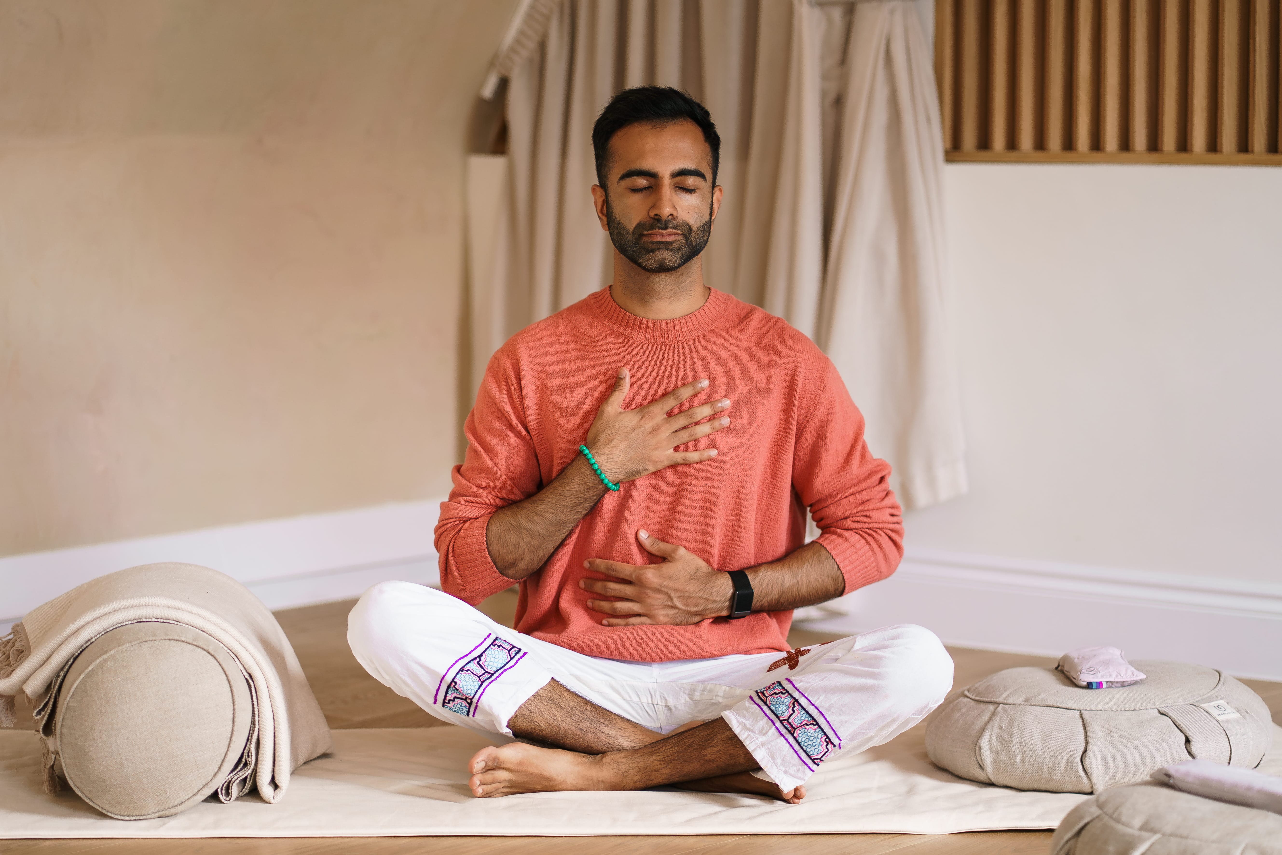 Ryan Samtani in a meditative breathwork pose, hands on chest